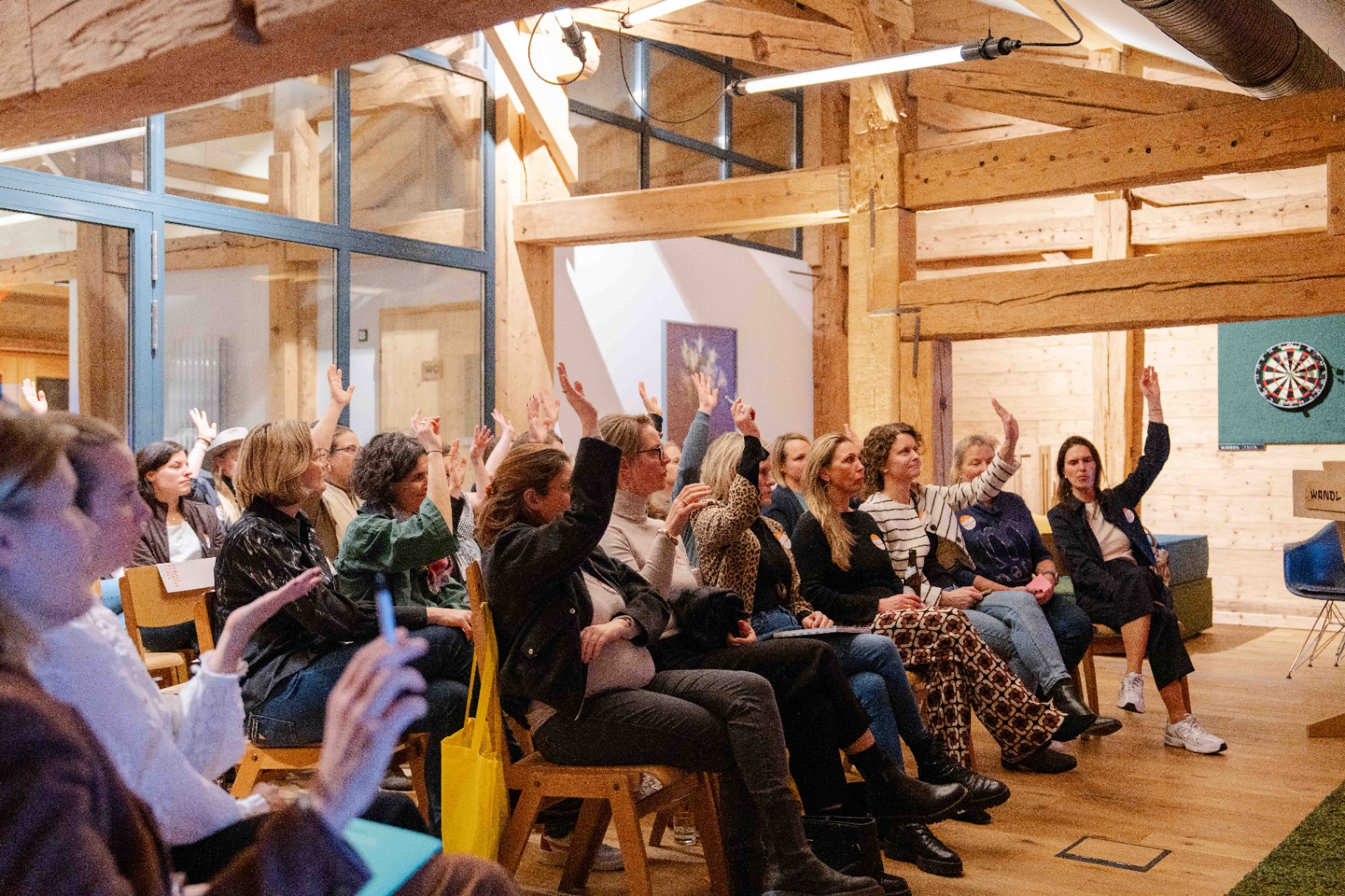Frauen heben die Hand bei einer Female Business Force Session im WANDL Ruhpolding